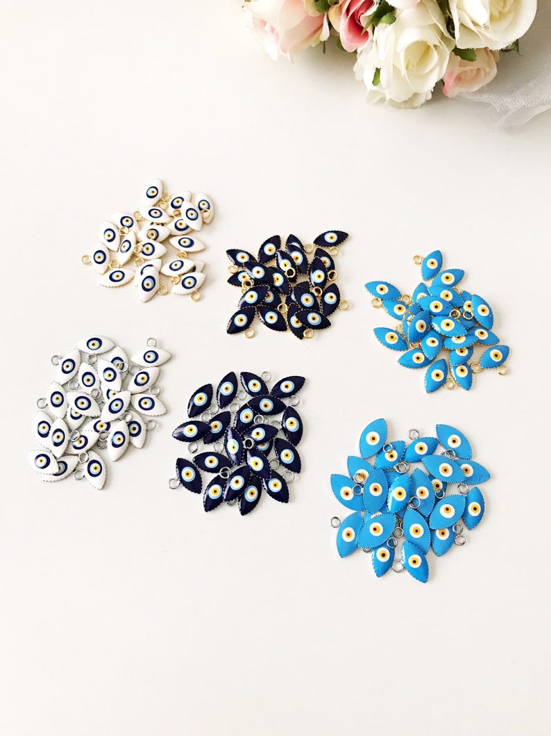 A bulk set of 20 blue evil eye beads, featuring intricate designs and a shiny finish, ideal for jewelry making and DIY projects.