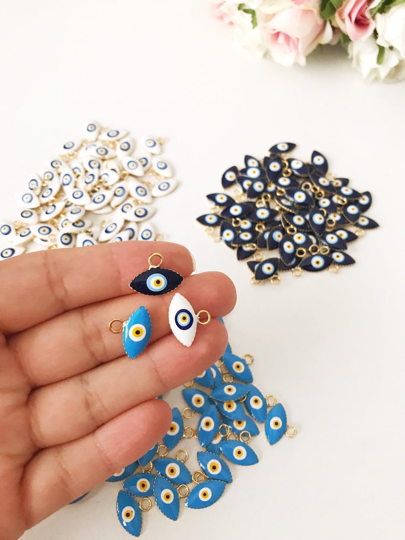 A bulk set of 20 blue evil eye beads, featuring intricate designs and a shiny finish, ideal for jewelry making and DIY projects.