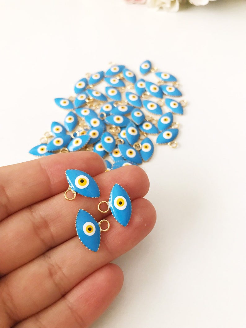 A bulk set of 20 blue evil eye beads, featuring intricate designs and a shiny finish, ideal for jewelry making and DIY projects.