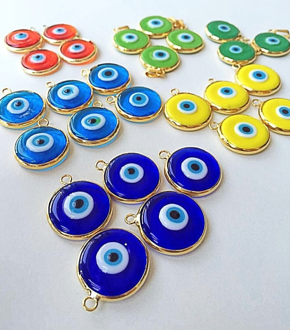 A collection of 22mm glass evil eye charms in various colors, featuring a matte 22K gold plated finish, perfect for jewelry making.