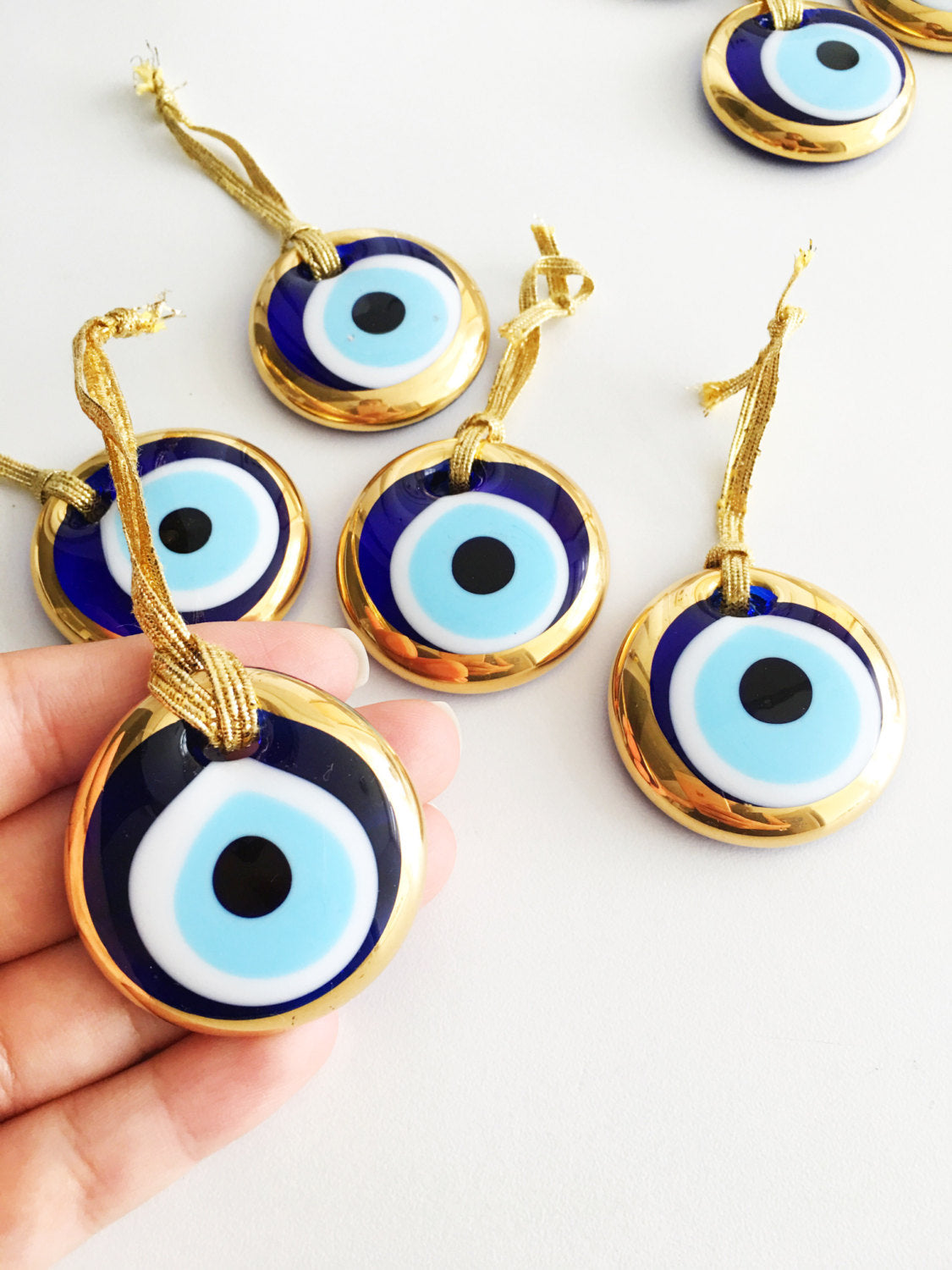 Two handmade gold evil eye beads, each 4.5cm, with a gold rope for hanging, symbolizing protection and good luck.