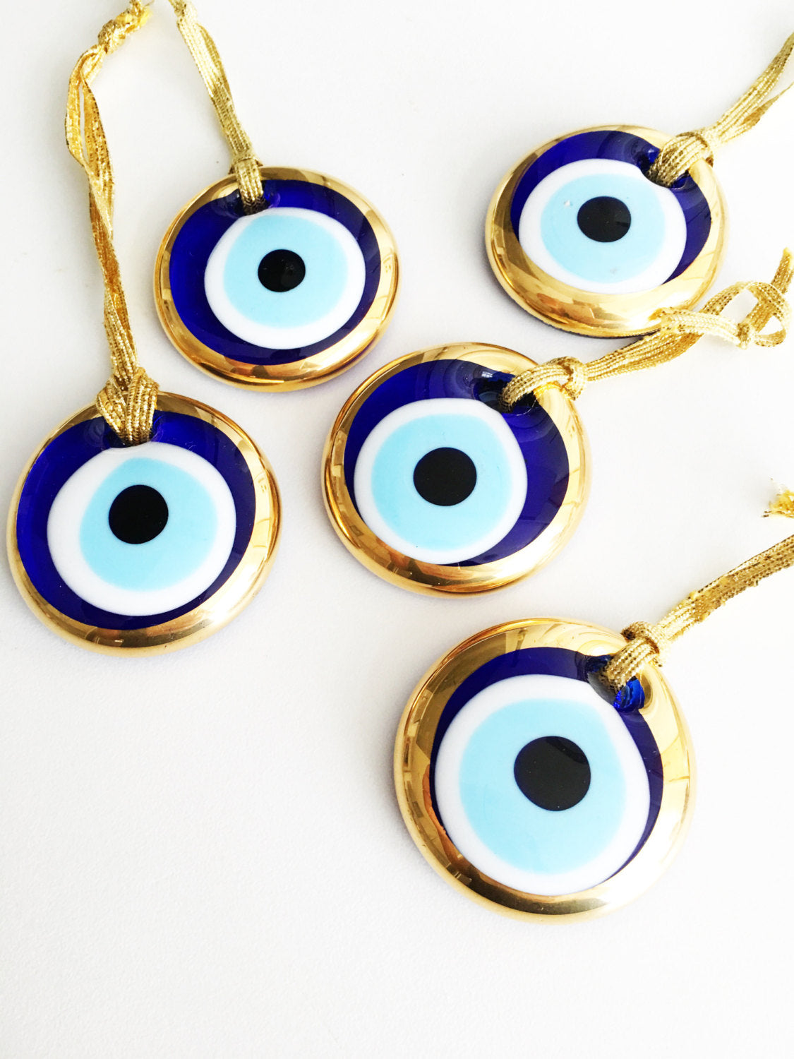 Two handmade gold evil eye beads, each 4.5cm, with a gold rope for hanging, symbolizing protection and good luck.