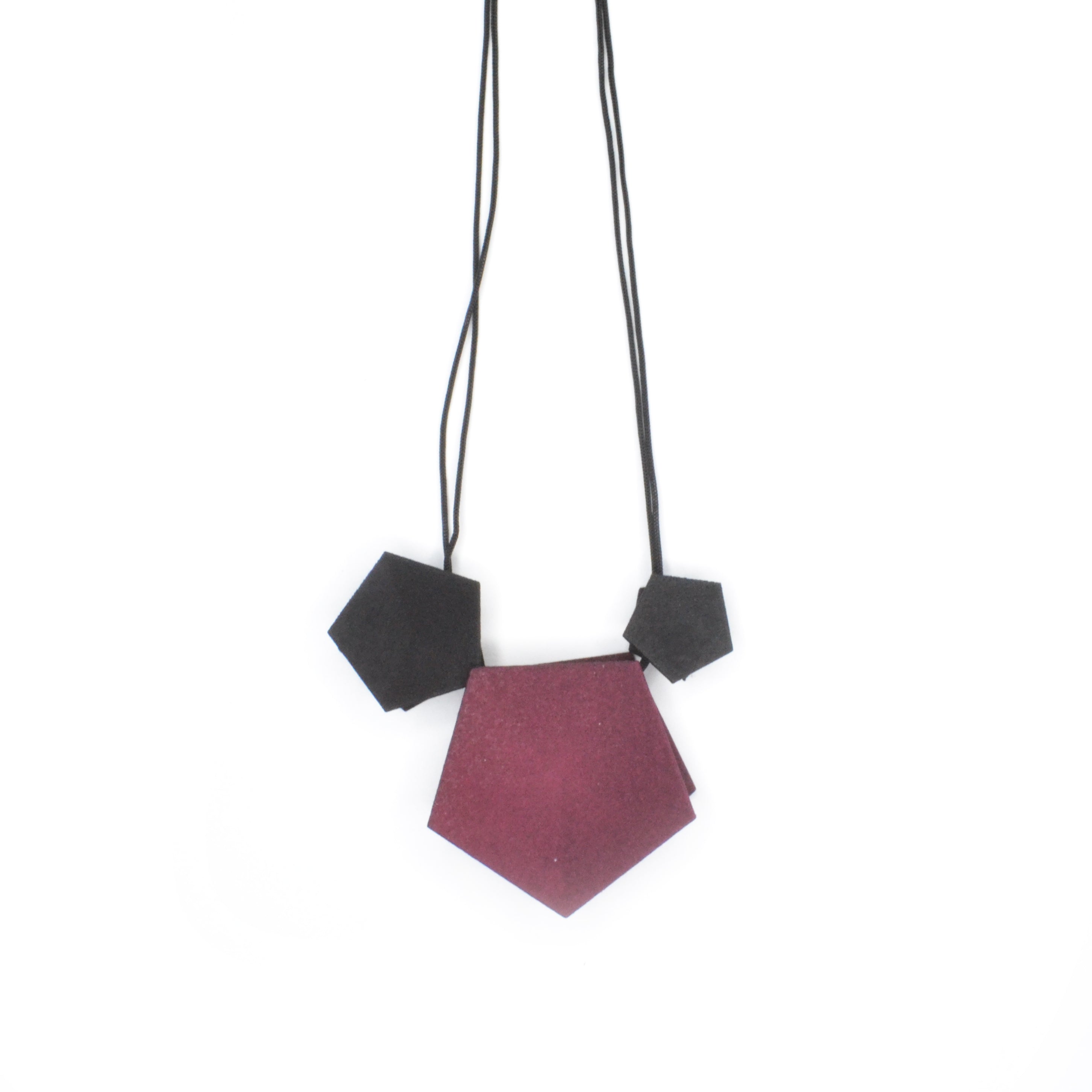 Vertigo 3 Element Necklace featuring three geometric pentagons on a black nylon cord, showcasing vibrant colors and a sterling silver bead for length adjustment.