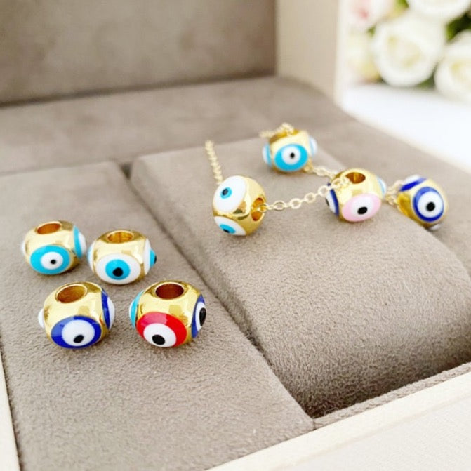 Three colorful brass evil eye charms designed for Pandora bracelets, showcasing blue, turquoise, and white colors.