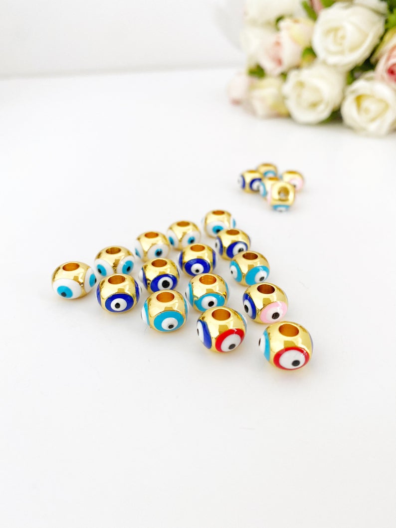 Three colorful brass evil eye charms designed for Pandora bracelets, showcasing blue, turquoise, and white colors.