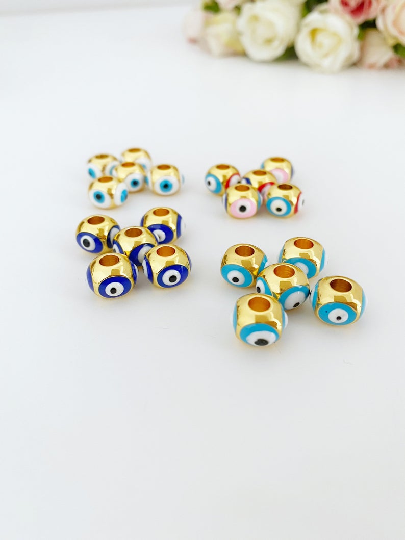 Three colorful brass evil eye charms designed for Pandora bracelets, showcasing blue, turquoise, and white colors.