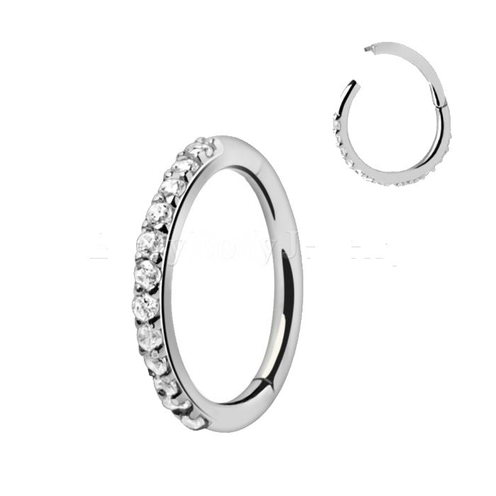 A 316L stainless steel seamless clicker ring adorned with multiple prong-set cubic zirconia stones, showcasing its elegant design and versatility.