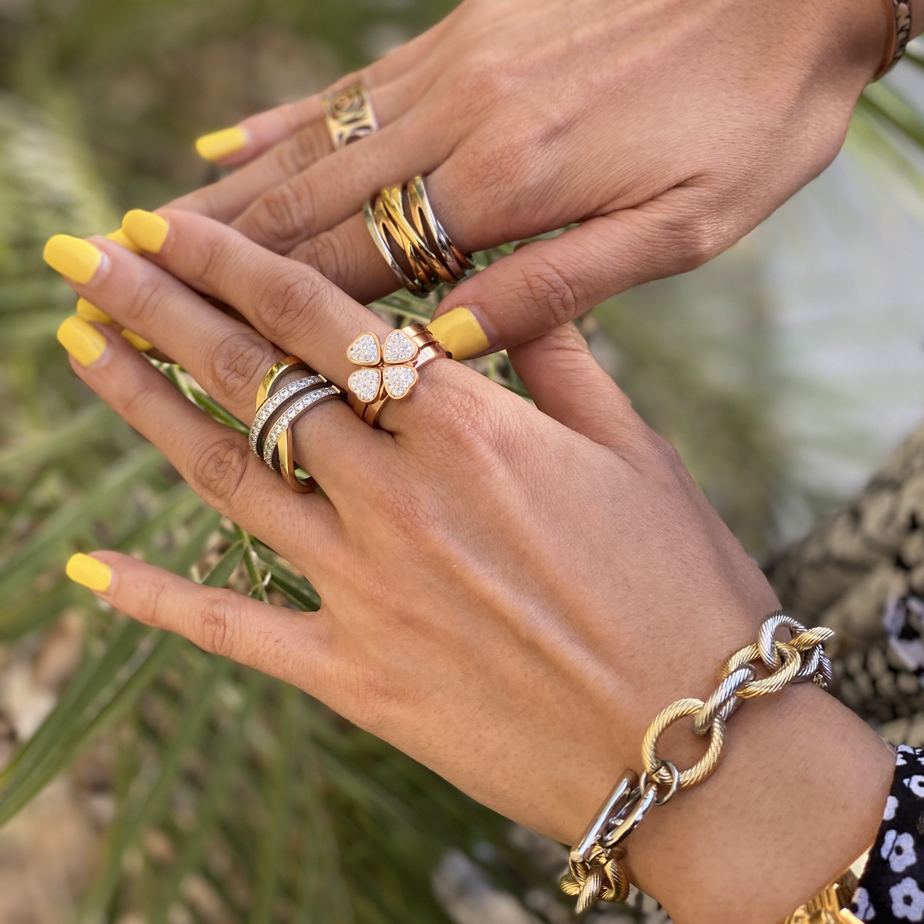 A set of three gold clover rings with cubic zirconia, showcasing a stylish and elegant design.