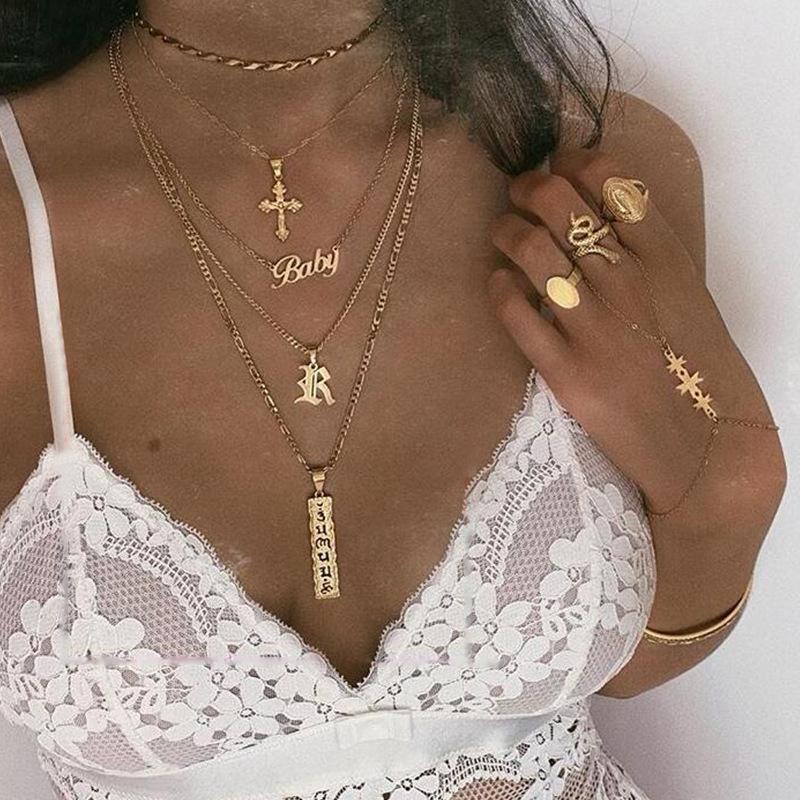 A beautiful 4 Piece Baby Cross Necklace featuring an 18K gold plated finish, designed for children with a lobster clasp and link chain.