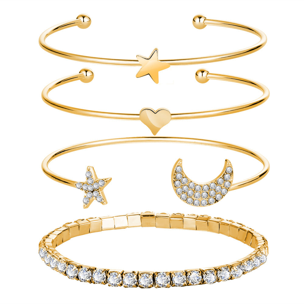 A luxurious 4 Piece Celestial Bangle Set featuring 18K gold plating and sparkling crystals, elegantly displayed on a soft surface.