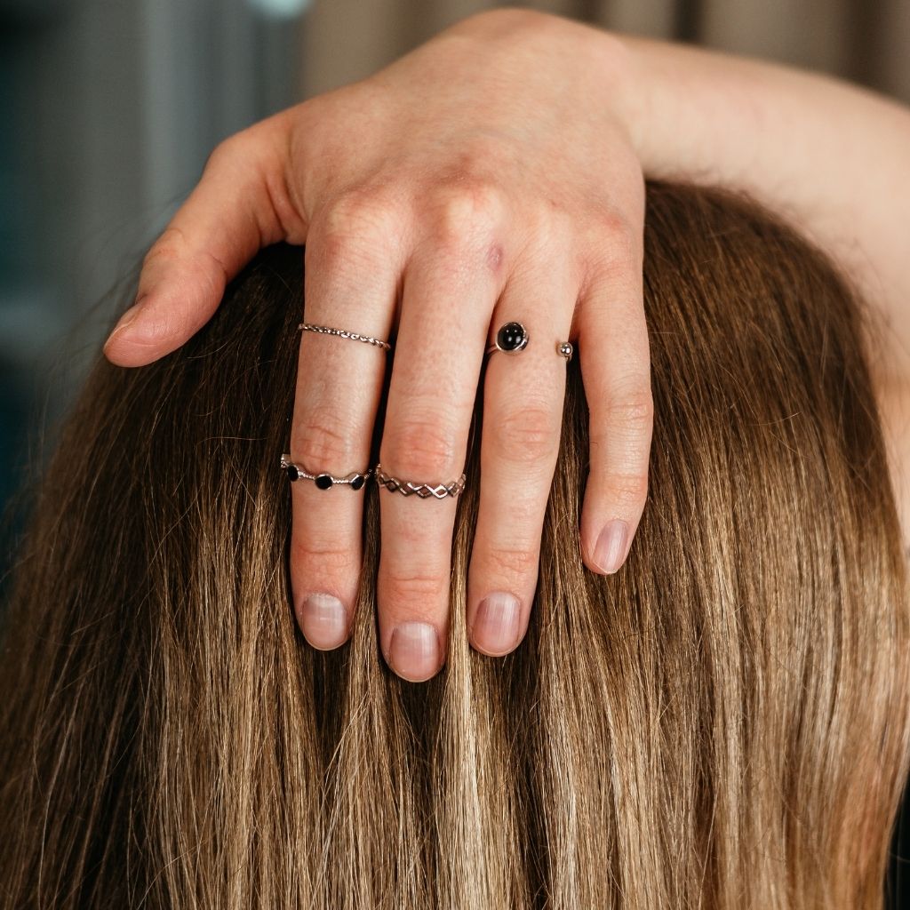 A stylish 4 piece silver and black stone stacking dainty open knuckle ring set, showcasing elegant designs with black gemstones.