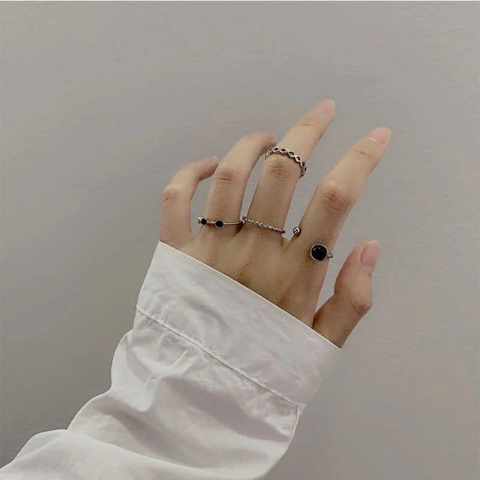 A stylish 4 piece silver and black stone stacking dainty open knuckle ring set, showcasing elegant designs with black gemstones.