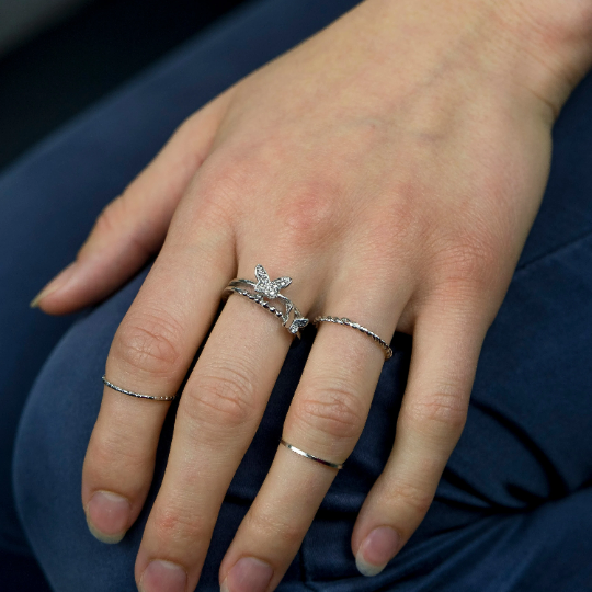 A set of four silver bohemian butterfly stackable rings, showcasing intricate designs and a gleaming finish, perfect for versatile styling.