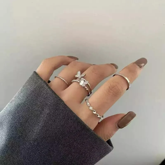 A set of four silver bohemian butterfly stackable rings, showcasing intricate designs and a gleaming finish, perfect for versatile styling.