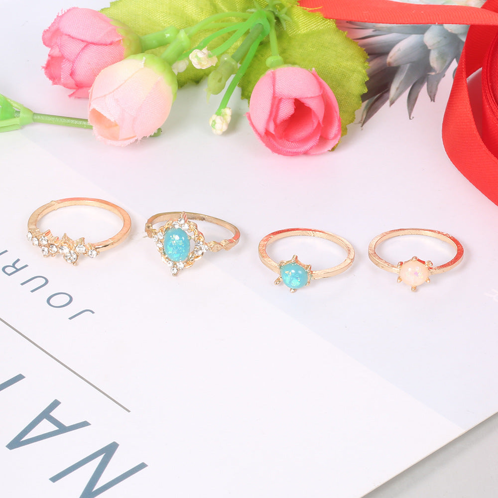 A beautiful 4-piece ring set featuring opal and white crystals, crafted from 14K gold-plated brass with a micro-pavé setting.