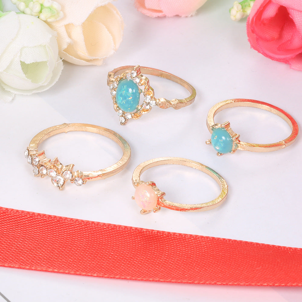 A beautiful 4-piece ring set featuring opal and white crystals, crafted from 14K gold-plated brass with a micro-pavé setting.