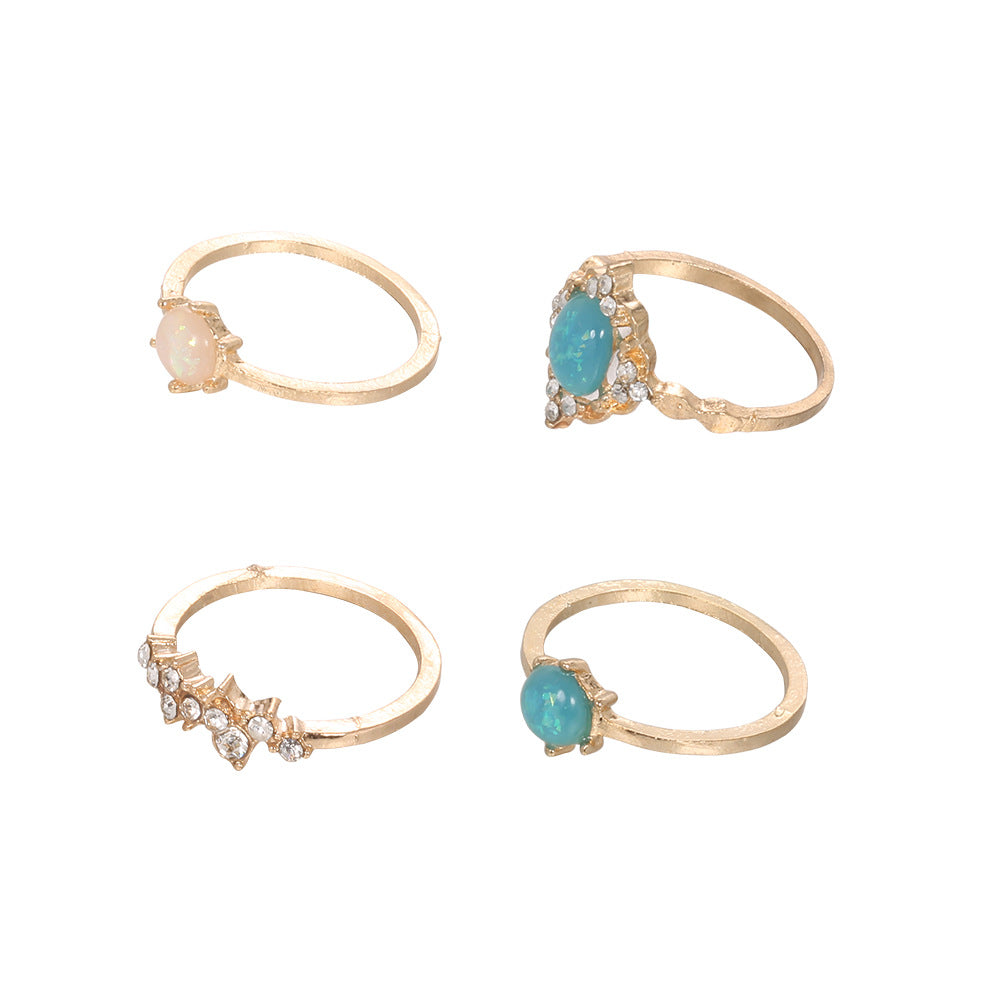 A beautiful 4-piece ring set featuring opal and white crystals, crafted from 14K gold-plated brass with a micro-pavé setting.