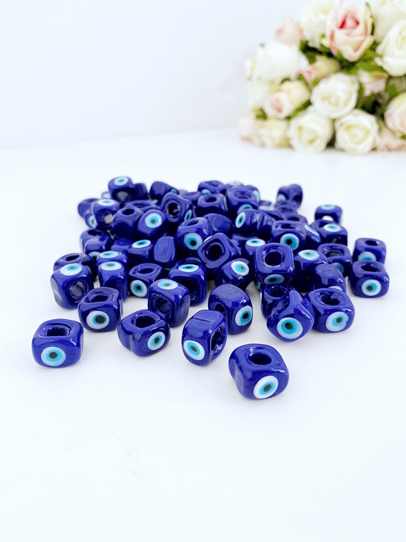 Five blue glass evil eye cube beads, each 10mm, showcasing a protective charm for DIY jewelry making.