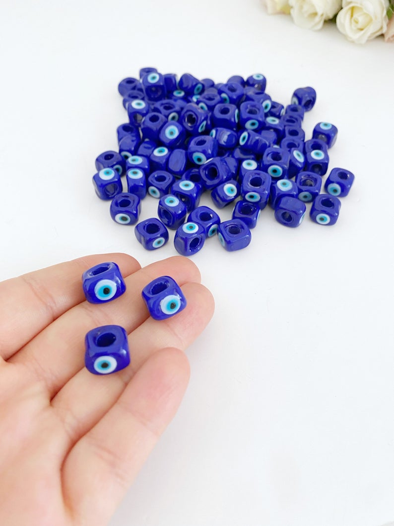 Five blue glass evil eye cube beads, each 10mm, showcasing a protective charm for DIY jewelry making.