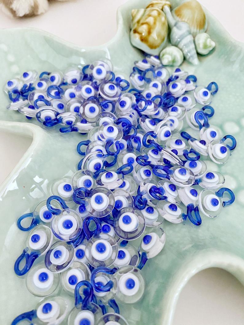 Five clear Murano glass evil eye beads, each 15mm in size, featuring a protective charm design.