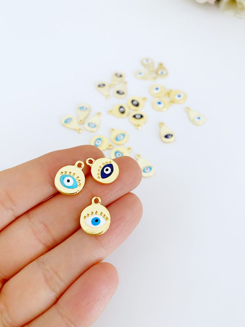 Five rose gold evil eye charms with customizable eye colors, perfect for jewelry making.