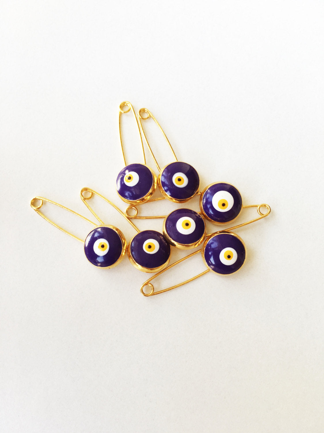 Set of 5 blue evil eye safety pins with gold plating, designed for baby protection and style.