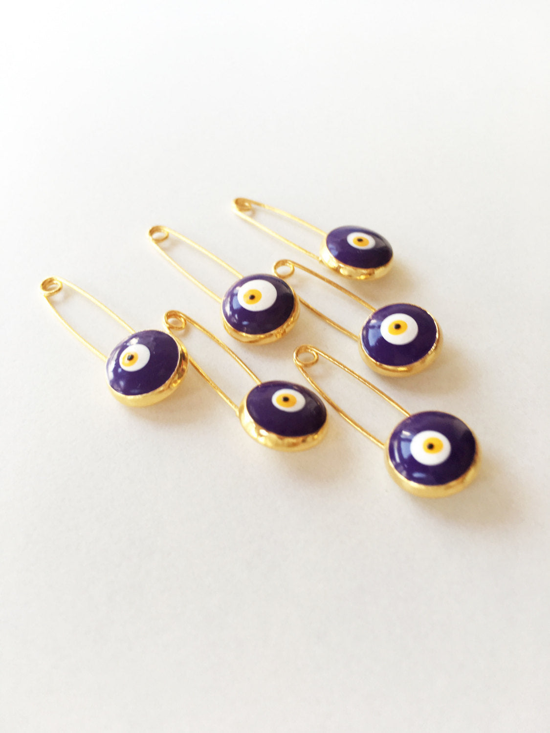 Set of 5 blue evil eye safety pins with gold plating, designed for baby protection and style.