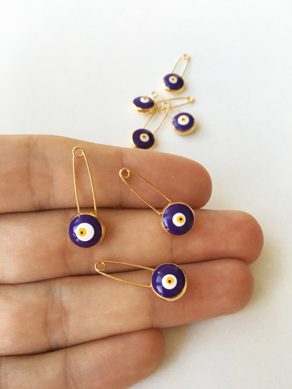 Set of 5 blue evil eye safety pins with gold plating, designed for baby protection and style.