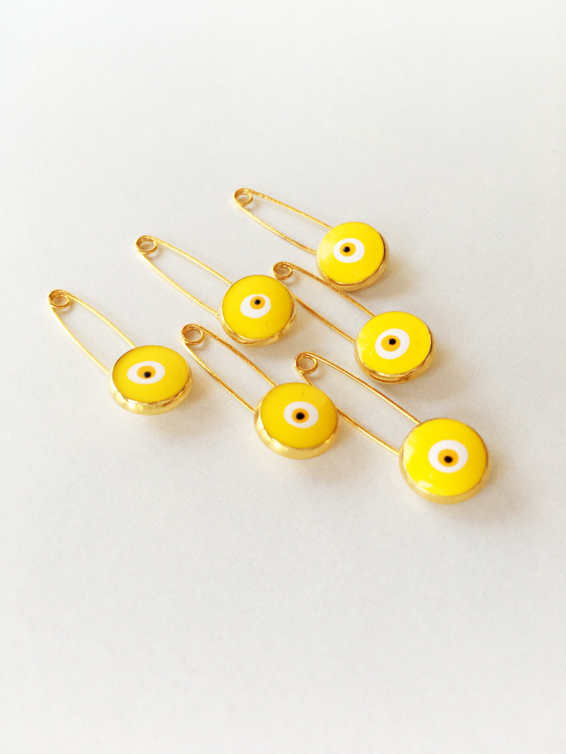 Set of 5 gold plated lucky evil eye safety pins with colorful enamel designs, perfect for baby protection.