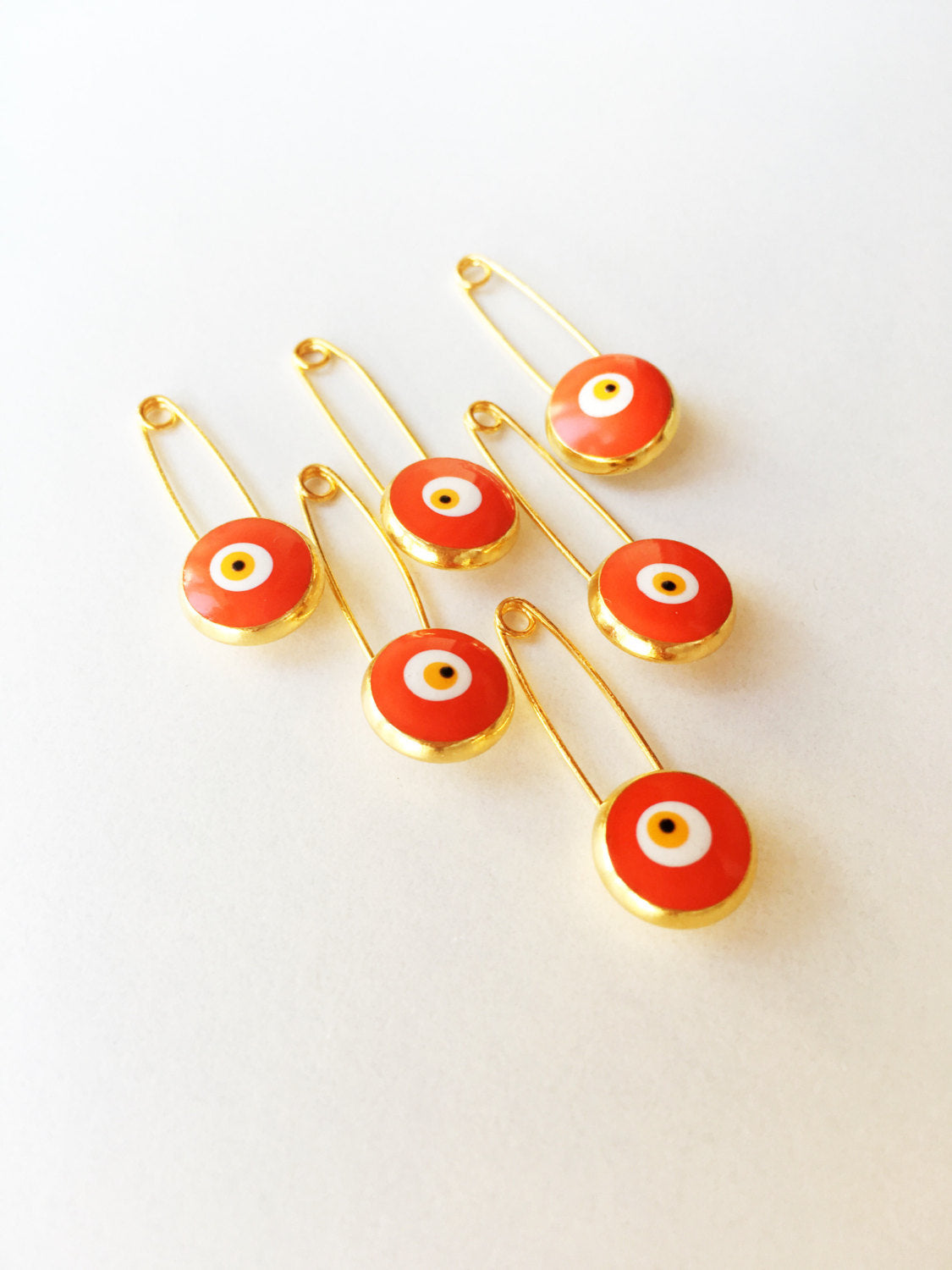 Five gold plated lucky evil eye safety pins in various colors, designed for baby protection and style.