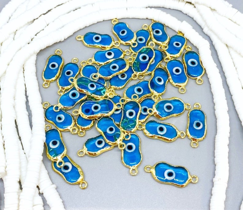 Five handmade transparent blue evil eye beads made of Murano glass, showcasing intricate designs and a stainless steel frame.