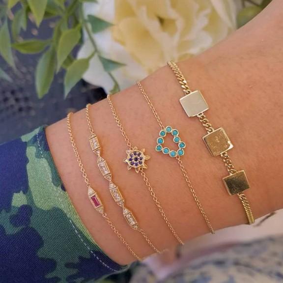 A stylish 5 piece bracelet set featuring cute and kitschy designs with colored crystals, elegantly plated in 14K gold.