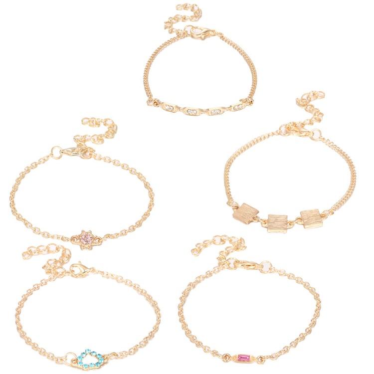 A stylish 5 piece bracelet set featuring cute and kitschy designs with colored crystals, elegantly plated in 14K gold.