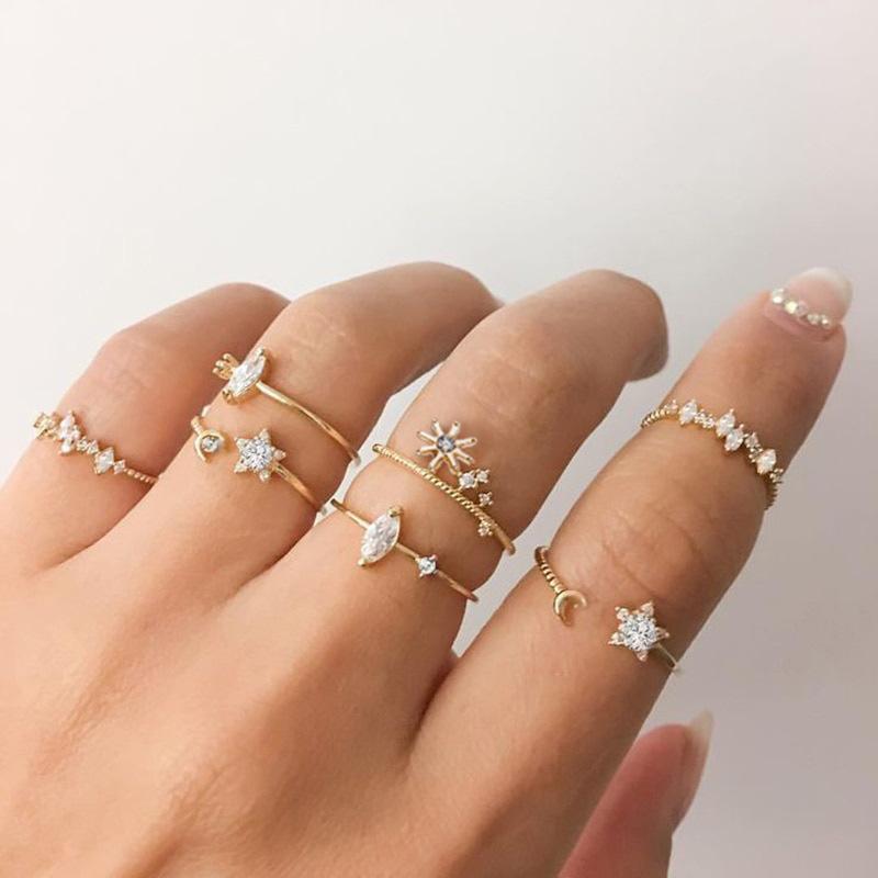 5 Piece Stars Ring Set featuring sparkling crystals and 18K gold plating, elegantly displayed on a soft surface.