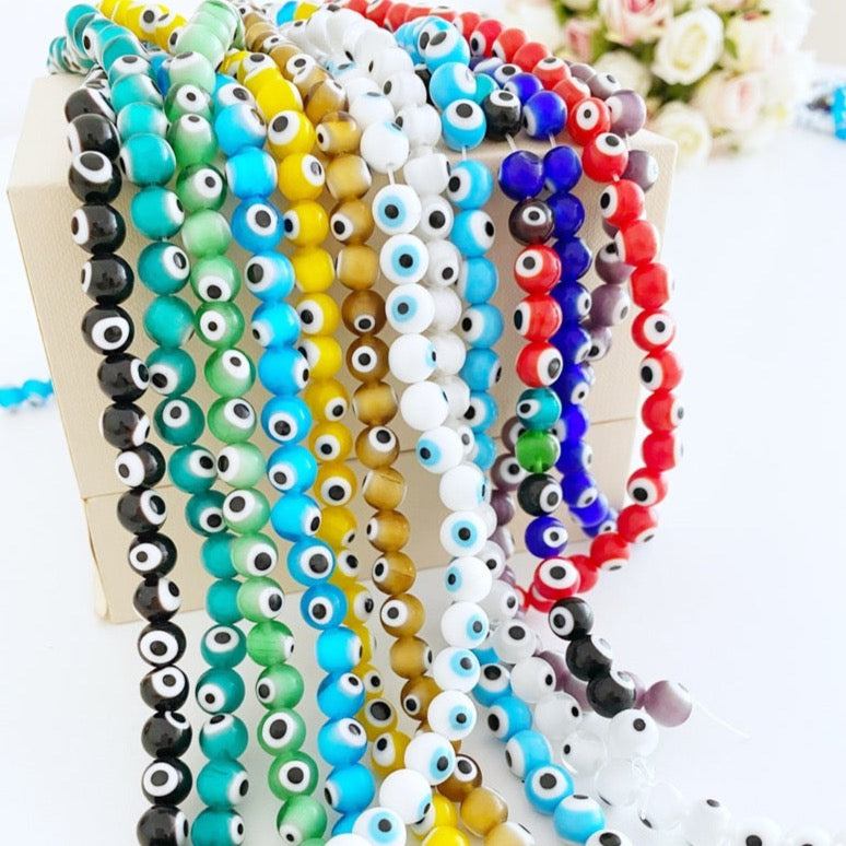 A collection of 50 pcs 8mm round glass evil eye beads in various colors including red, turquoise, and dark blue, ideal for jewelry making.