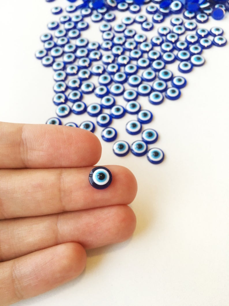 A collection of 500 dark blue evil eye cabochons made from resin, perfect for DIY jewelry and crafts.