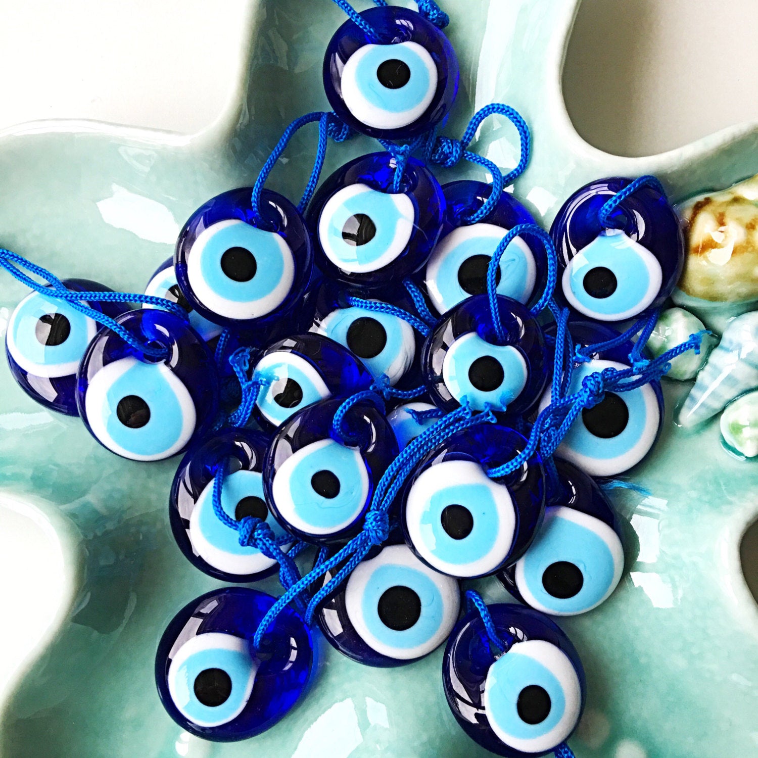 Five unique evil eye wedding favors with beads and personalized cards, symbolizing protection and good luck.