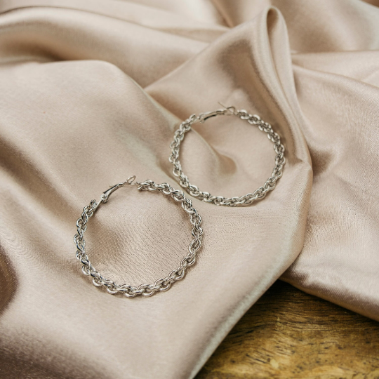 A pair of 60MM silver spiral braided hoop earrings showcasing intricate craftsmanship and a modern design.