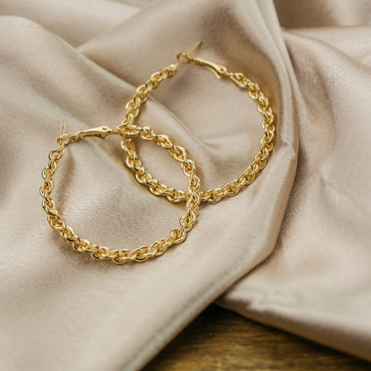 A pair of 60MM silver spiral braided hoop earrings showcasing intricate craftsmanship and a modern design.