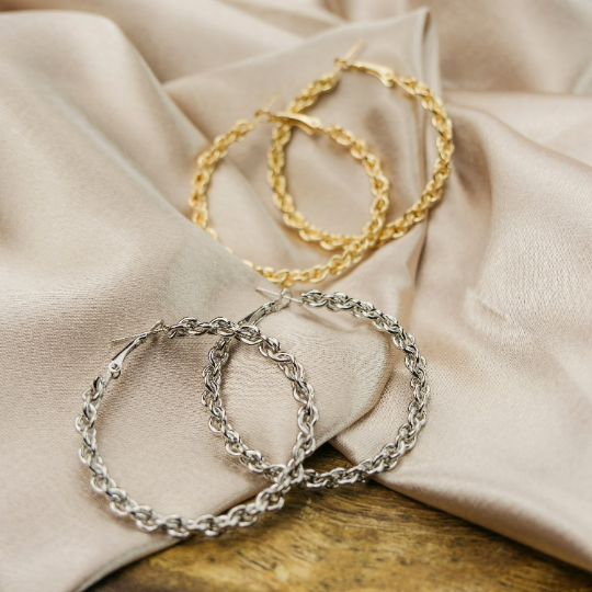 A pair of 60MM silver spiral braided hoop earrings showcasing intricate craftsmanship and a modern design.