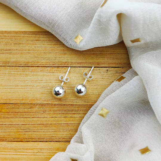 A pair of 6mm pure silver solid unisex round ball dot studs, showcasing their minimalistic and elegant design.