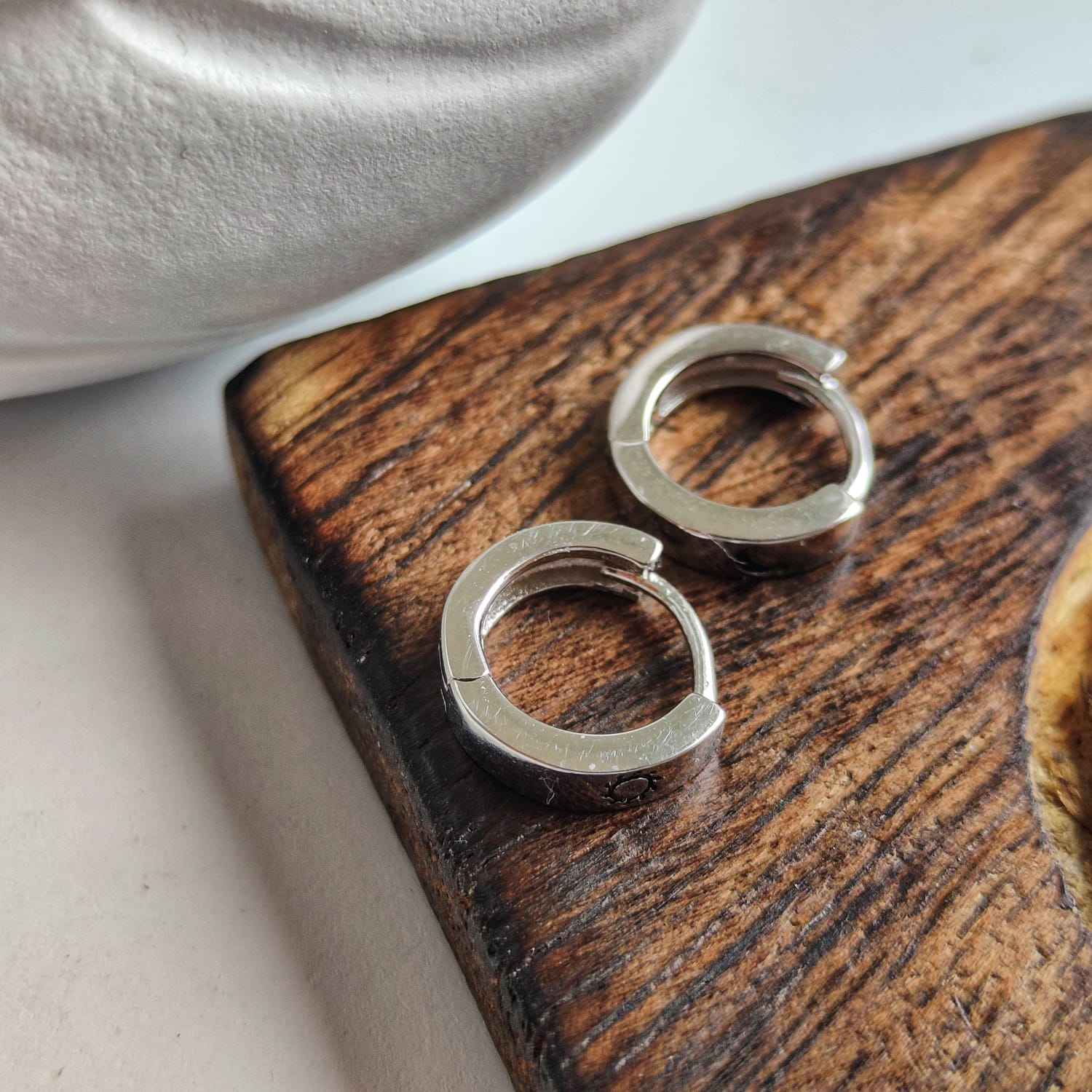 A pair of 925 silver slim hoop earrings featuring a minimalist sun and moon design, perfect for unisex wear.