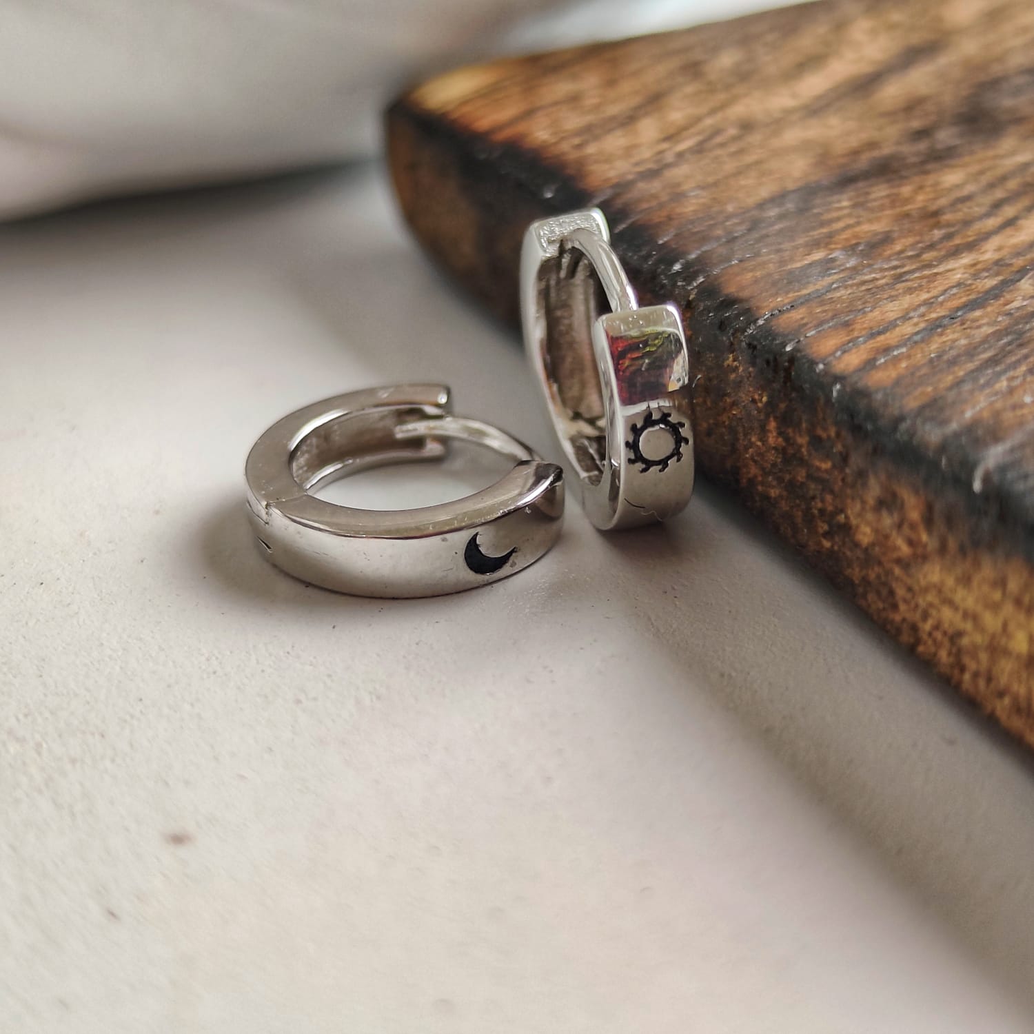 A pair of 925 silver slim hoop earrings featuring a minimalist sun and moon design, perfect for unisex wear.