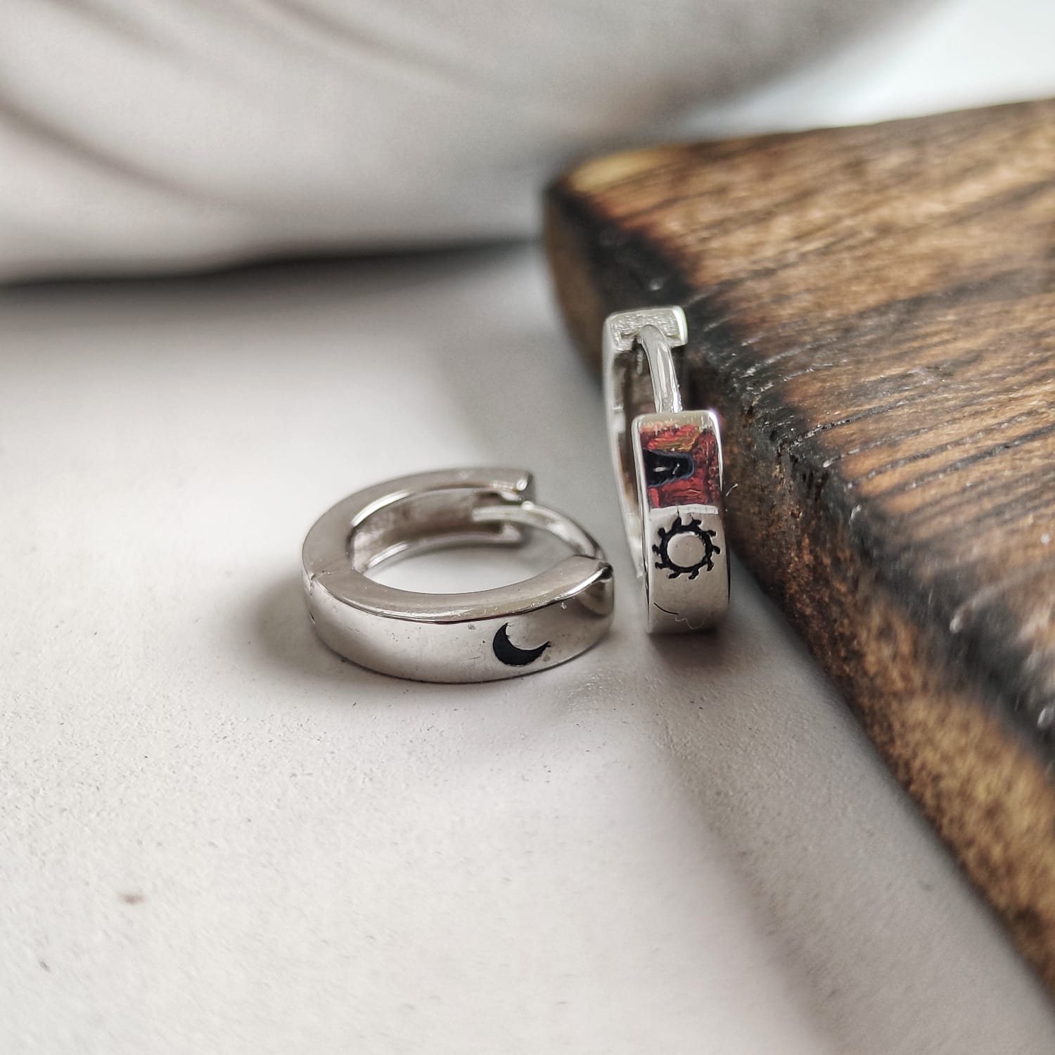 A pair of 925 silver slim hoop earrings featuring a minimalist sun and moon design, perfect for unisex wear.