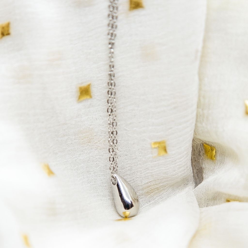 A delicate 925 silver small teardrop necklace featuring a slim elegant droplet pendant, showcasing its shiny finish and adjustable length.