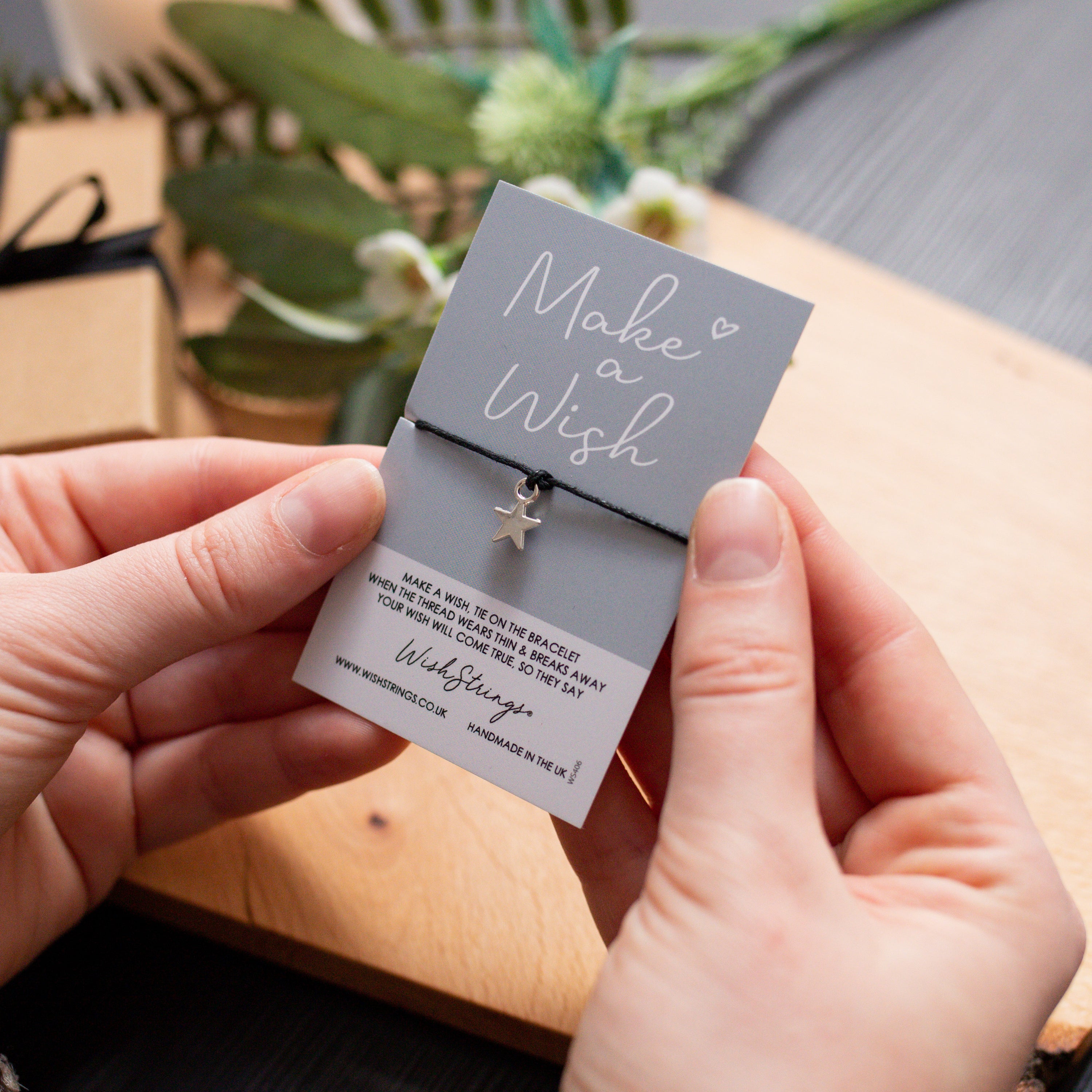 A Big Hug WishStrings Wish Bracelet featuring a heart star-shaped charm on a waxed cotton cord, beautifully presented with an inspirational wish card.