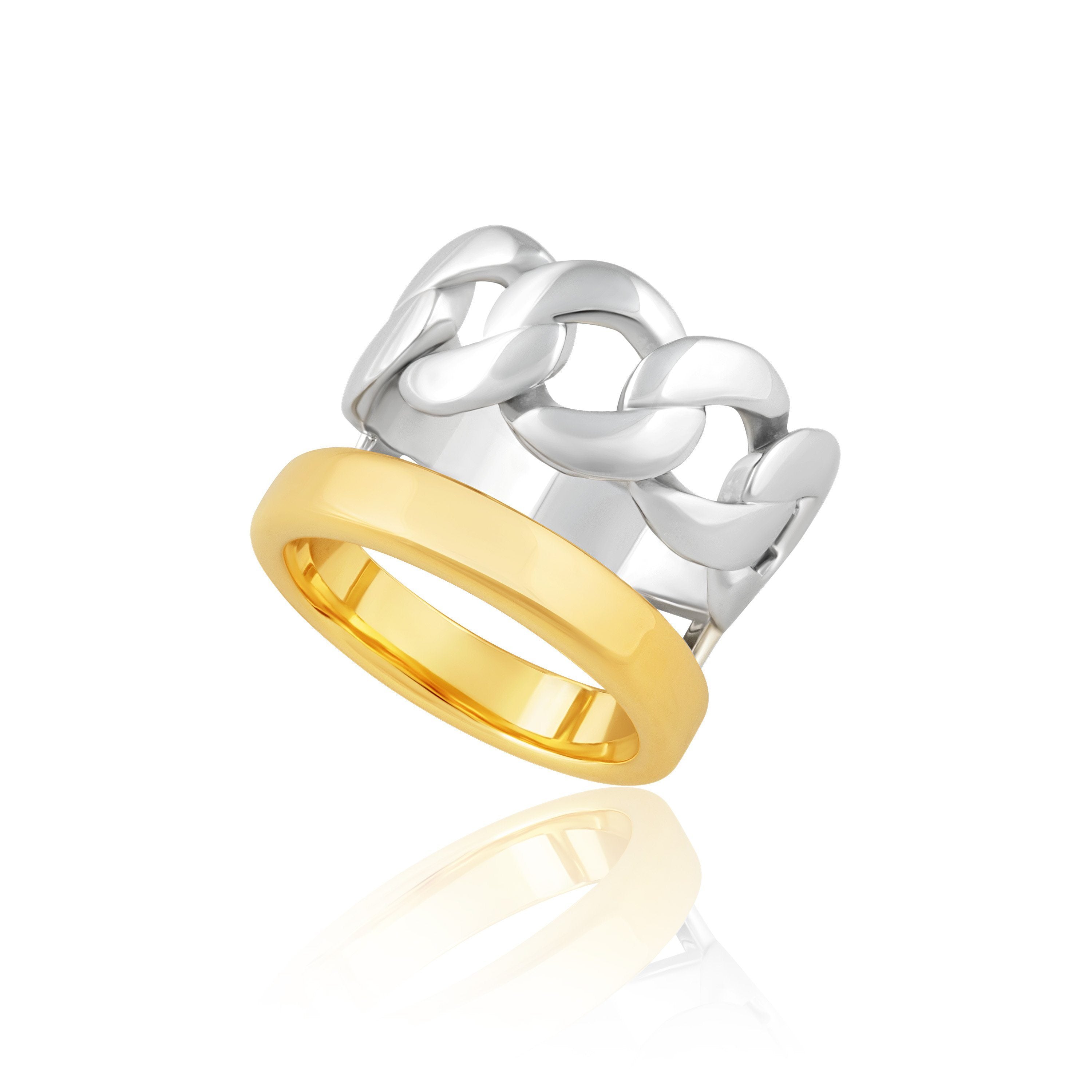 The Abby Chain Ring featuring a unique two-toned design with a silver chain band and a gold classic band, elegantly displayed on a soft surface.