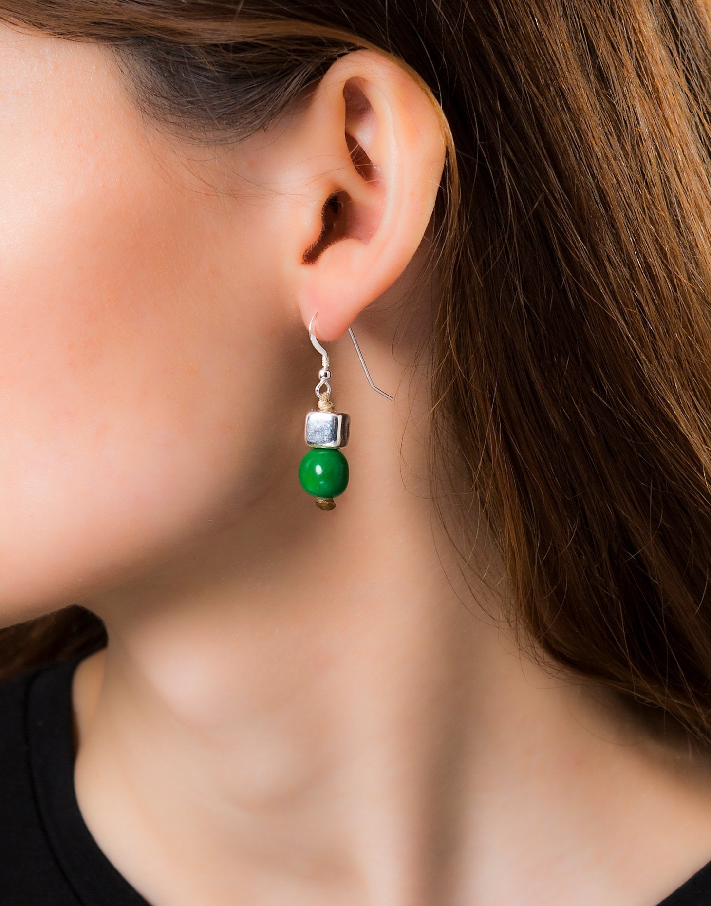 A pair of vibrant Acai Berry Earrings featuring pearl-sized acai seeds and silver accents, elegantly displayed in an eco-friendly bag.