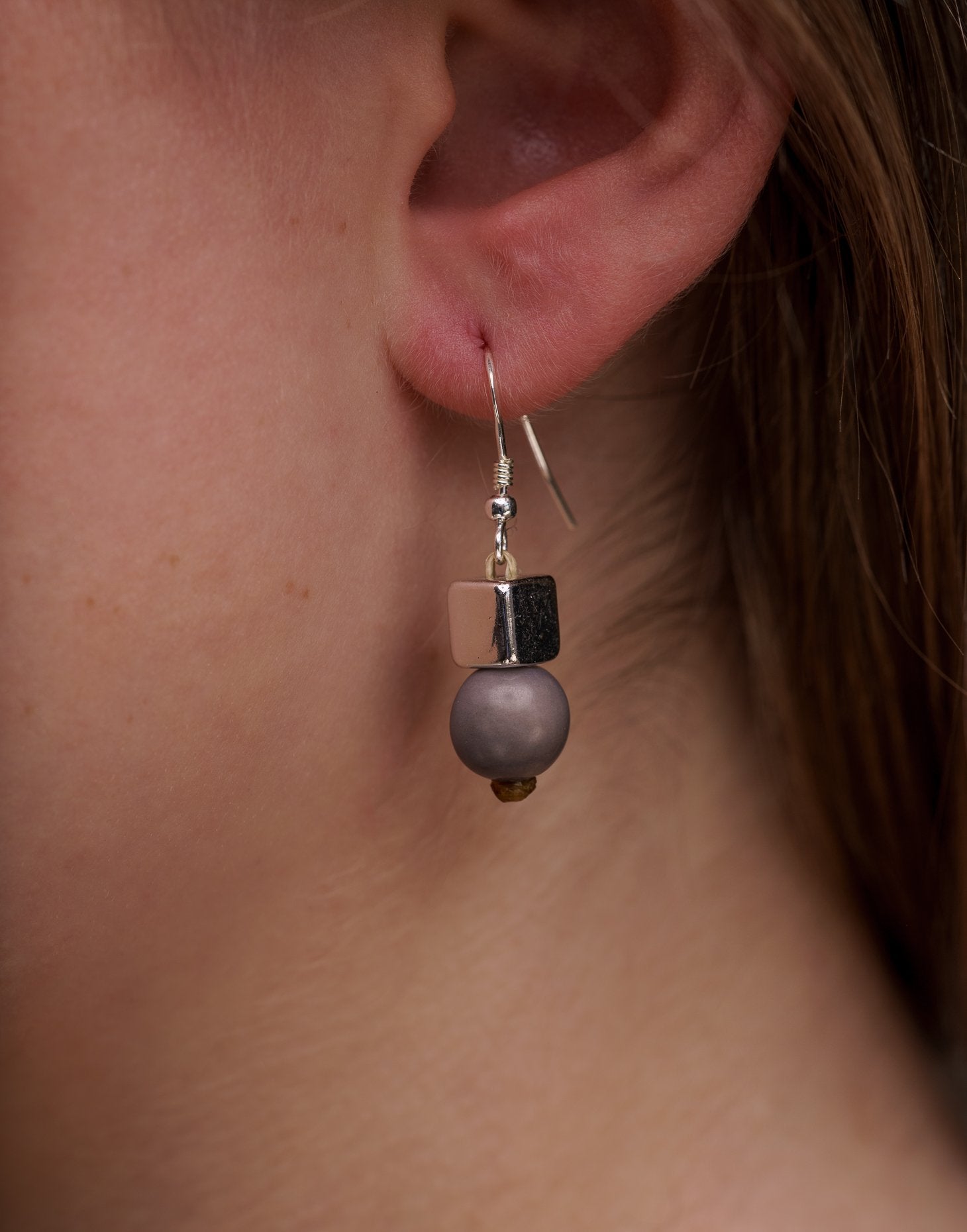 A pair of vibrant Acai Berry Earrings featuring pearl-sized acai seeds and silver accents, elegantly displayed in an eco-friendly bag.