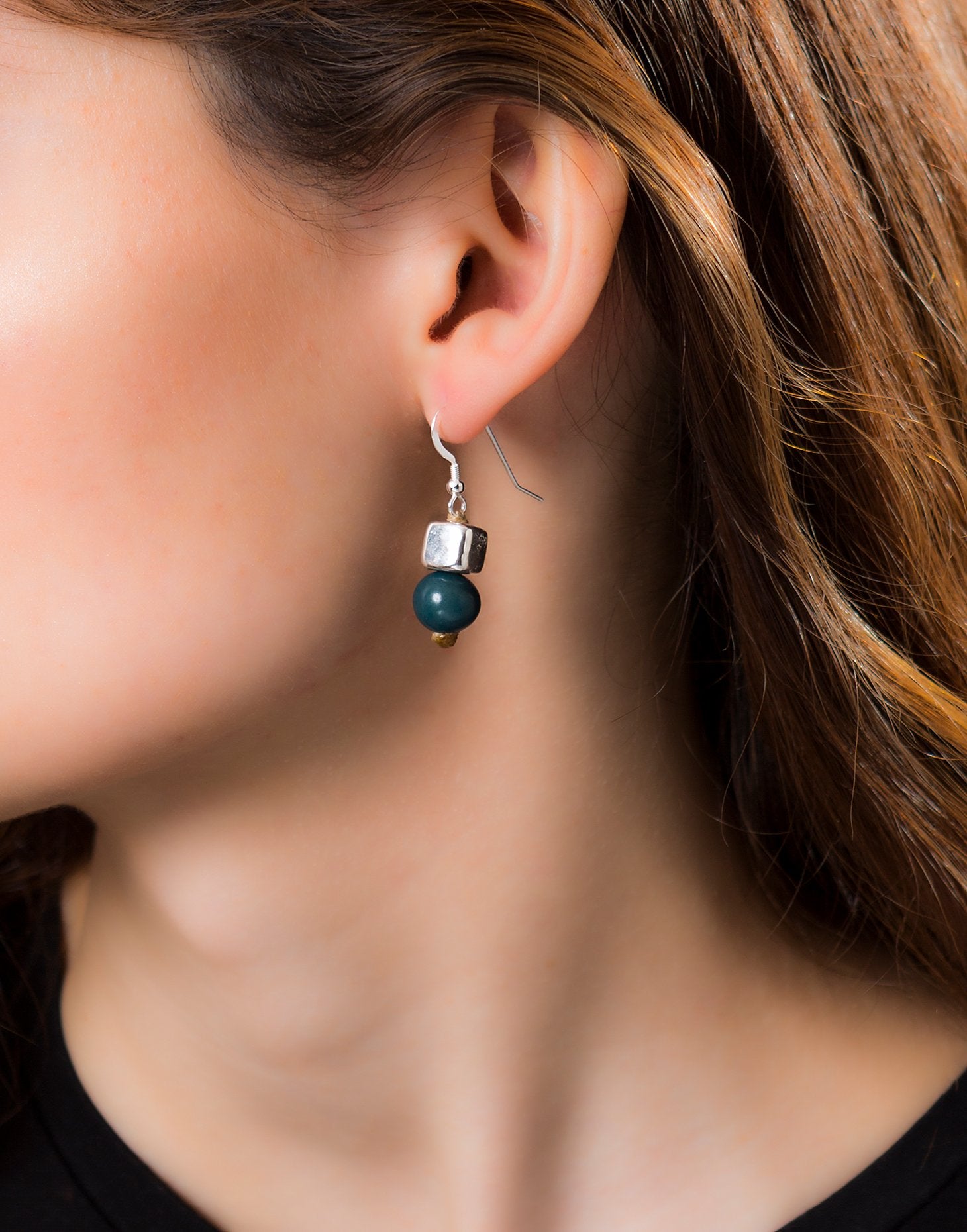 A pair of vibrant Acai Berry Earrings featuring pearl-sized acai seeds and silver accents, elegantly displayed in an eco-friendly bag.